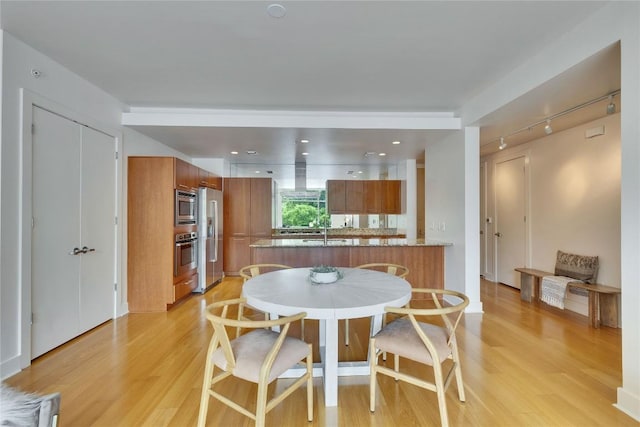210 Lee Barton Dr Unit 308, Austin, TX 78704 - dining space with rail lighting and light wood-style floors