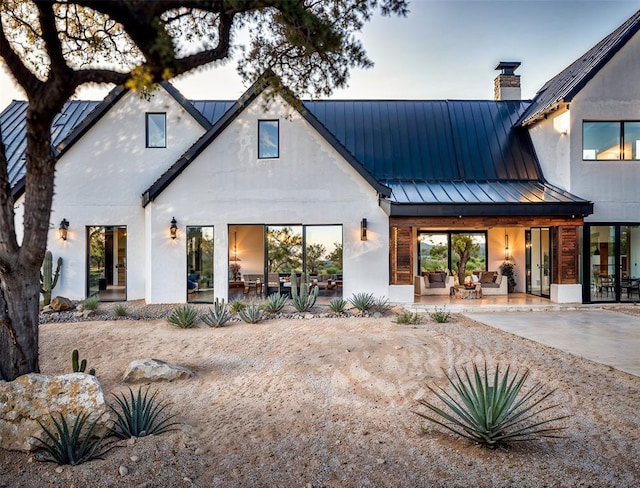 2121 Camino Way, Canyon Lake, TX 78133 - rear view of property with a standing seam roof, a metal roof, a patio, a chimney, and stucco siding