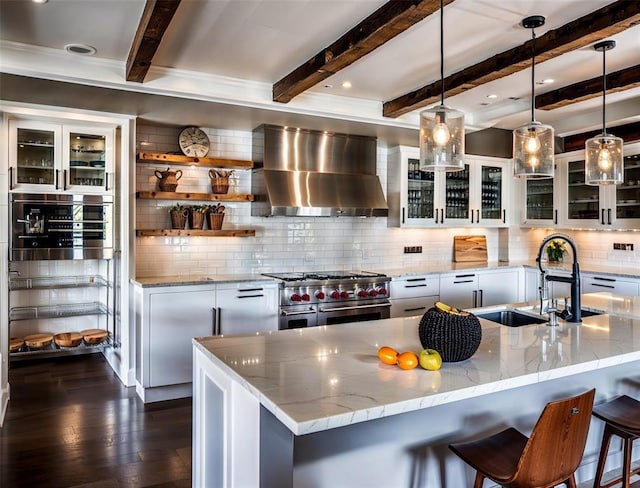 2121 Camino Way, Canyon Lake, TX 78133 - kitchen with wall chimney range hood, double oven range, tasteful backsplash, dark wood-style floors, and beamed ceiling