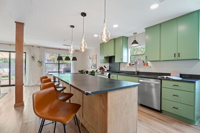 9706 Woodshire Dr, Austin, TX 78748 - kitchen with stainless steel appliances, green cabinets, dark countertops, light wood-style floors, and a kitchen island