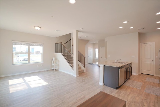 516 E Slaughter Ln Unit 2003, Austin, TX 78744 - kitchen with a sink, light wood-type flooring, open floor plan, a kitchen island with sink, and baseboards