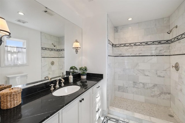 full bathroom with tiled shower, vanity, visible vents, recessed lighting, and toilet