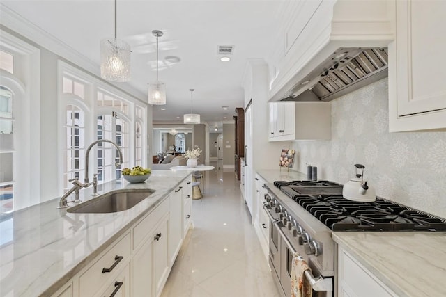1810 W 35th St, Austin, TX 78703 - kitchen featuring stainless steel range, custom range hood, white cabinetry, ornamental molding, and decorative light fixtures