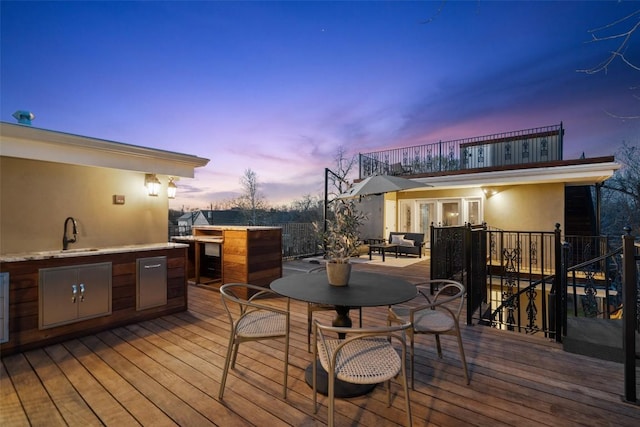 1810 W 35th St, Austin, TX 78703 - deck at dusk with exterior kitchen, outdoor dining space, and french doors