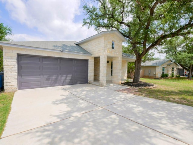 21711 Crystal Way, Lago Vista, TX 78645 - view of front of house with concrete driveway, stone siding, an attached garage, and a front yard