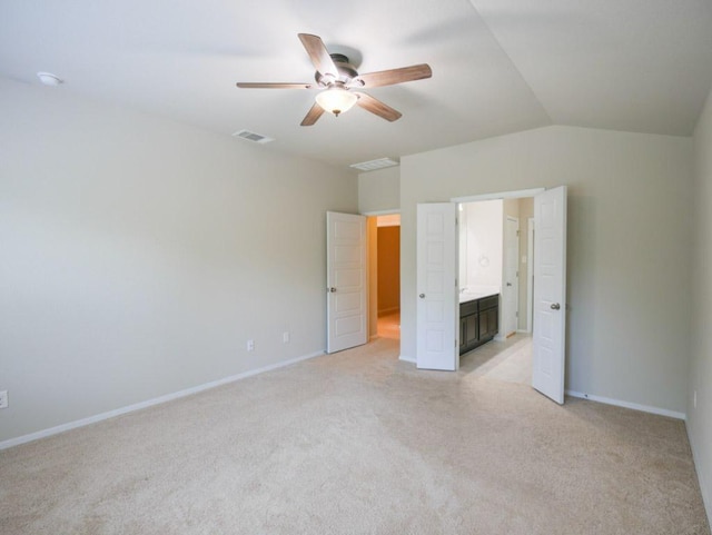 21711 Crystal Way, Lago Vista, TX 78645 - unfurnished bedroom featuring light carpet, vaulted ceiling, ensuite bathroom, and a ceiling fan