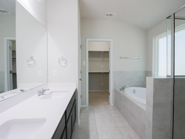 21711 Crystal Way, Lago Vista, TX 78645 - bathroom featuring tile patterned flooring, double vanity, a garden tub, a spacious closet, and lofted ceiling