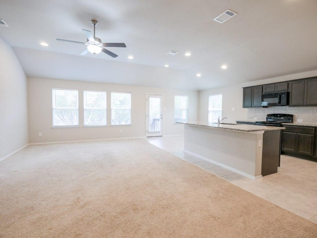 21711 Crystal Way, Lago Vista, TX 78645 - kitchen featuring black appliances, light colored carpet, a center island with sink, recessed lighting, and open floor plan