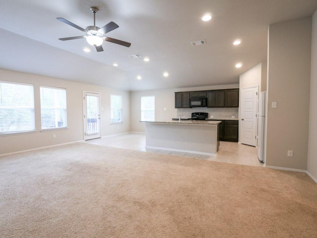 21711 Crystal Way, Lago Vista, TX 78645 - unfurnished living room featuring vaulted ceiling, light carpet, a ceiling fan, and recessed lighting
