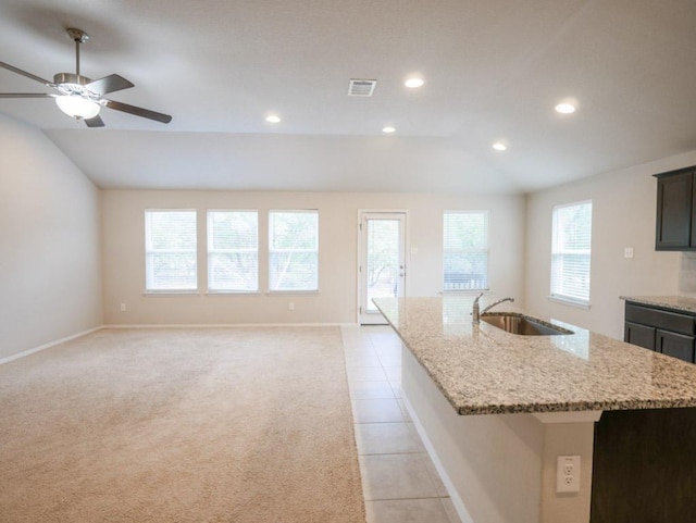 21711 Crystal Way, Lago Vista, TX 78645 - kitchen with lofted ceiling, a center island with sink, ceiling fan, light tile patterned flooring, and light stone countertops