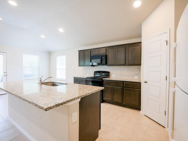 21711 Crystal Way, Lago Vista, TX 78645 - kitchen with black appliances, light stone countertops, decorative backsplash, a kitchen island with sink, and dark brown cabinets
