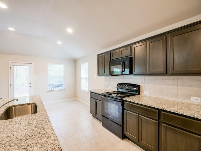 21711 Crystal Way, Lago Vista, TX 78645 - kitchen with black appliances, vaulted ceiling, tasteful backsplash, dark brown cabinets, and light tile patterned floors