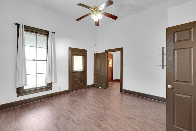 2705 E 2nd St, Austin, TX 78702 - spare room with wood finished floors, ceiling fan, baseboards, and a high ceiling