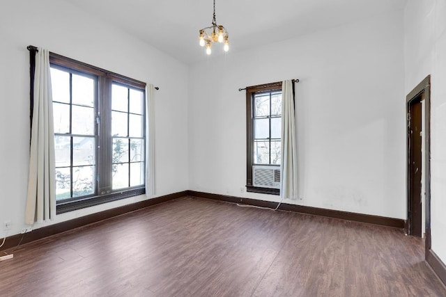 2705 E 2nd St, Austin, TX 78702 - empty room featuring dark wood finished floors, a chandelier, and baseboards
