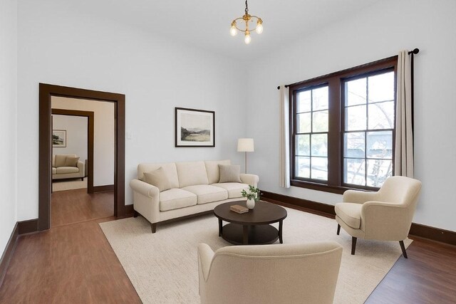 2705 E 2nd St, Austin, TX 78702 - living area featuring wood finished floors, a chandelier, and baseboards