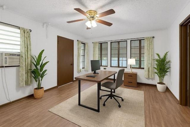 2705 E 2nd St, Austin, TX 78702 - home office with wood finished floors, cooling unit, a ceiling fan, a textured ceiling, and baseboards