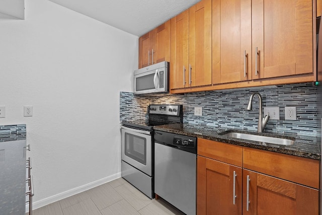 7685 Northcross Dr Unit 728, Austin, TX 78757 - kitchen featuring stainless steel appliances, tasteful backsplash, dark stone countertops, and brown cabinetry