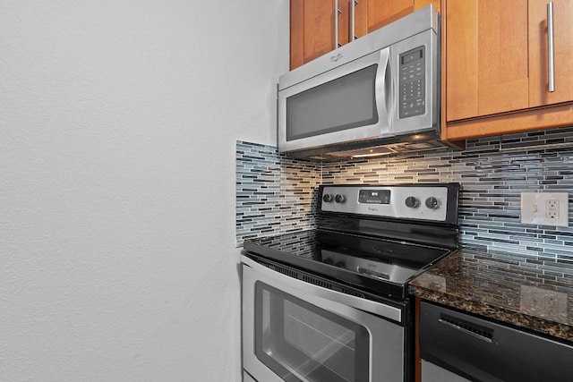 7685 Northcross Dr Unit 728, Austin, TX 78757 - kitchen with appliances with stainless steel finishes, backsplash, dark stone countertops, a textured wall, and brown cabinetry