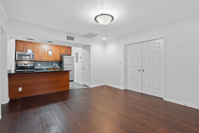 7685 Northcross Dr Unit 728, Austin, TX 78757 - kitchen featuring stainless steel appliances, dark countertops, dark wood-style floors, brown cabinetry, and crown molding