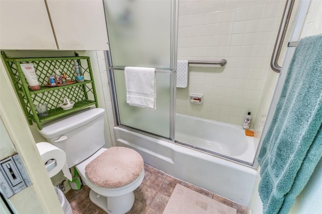bathroom with toilet and bath / shower combo with glass door