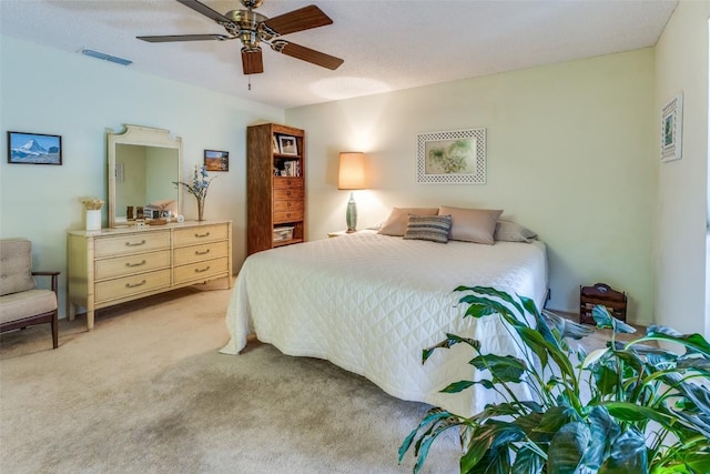 bedroom featuring visible vents, a ceiling fan, and light colored carpet