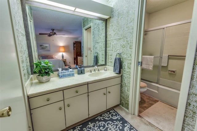 ensuite bathroom featuring shower / bath combination with glass door, toilet, a ceiling fan, vanity, and connected bathroom