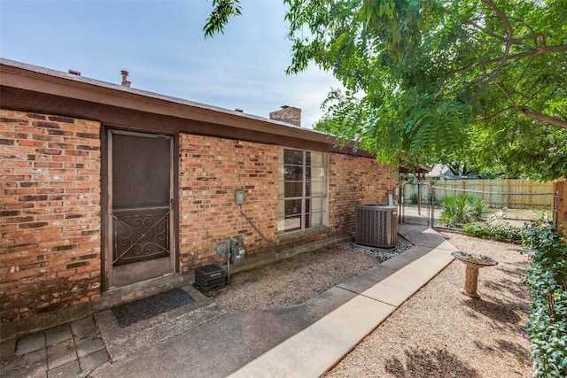 10116 Willfield Dr, Austin, TX 78753 - entrance to property with central AC unit, a chimney, and brick siding