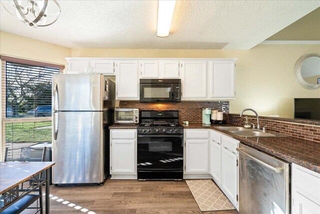 14300 Anita Marie Ln, Austin, TX 78728 - kitchen featuring black appliances, backsplash, white cabinets, dark countertops, and light wood-style flooring