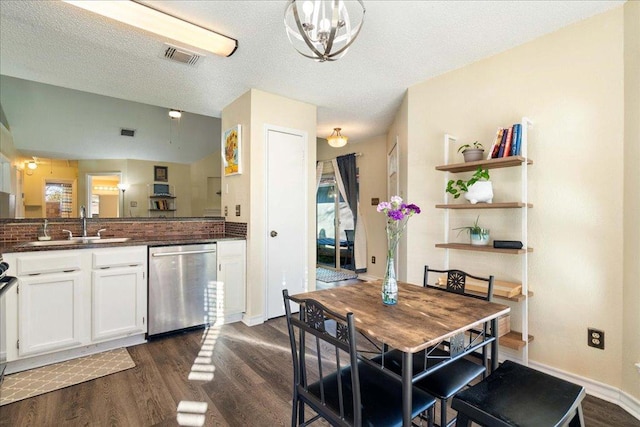 14300 Anita Marie Ln, Austin, TX 78728 - dining area with dark wood-style flooring, a textured ceiling, and a chandelier