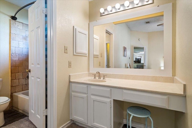 bathroom featuring toilet, vanity, and washtub / shower combination