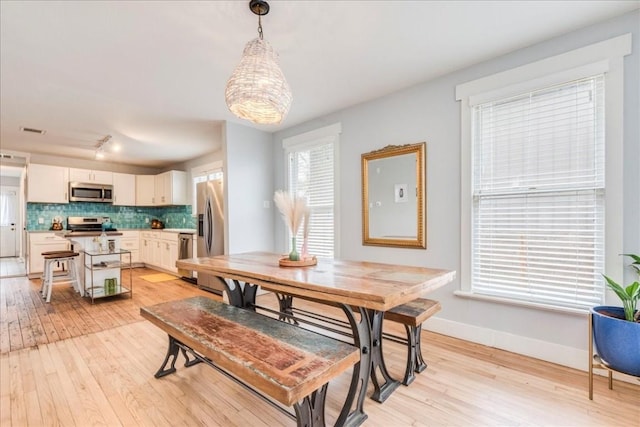 203 Ben Howell Dr, Austin, TX 78704 - dining area featuring light wood-style flooring and rail lighting