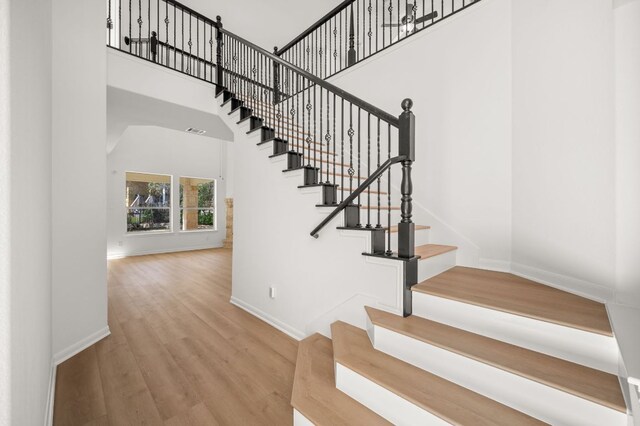 14309 Broadwinged Hawk Dr, Austin, TX 78738 - stairway featuring baseboards, wood finished floors, and a high ceiling