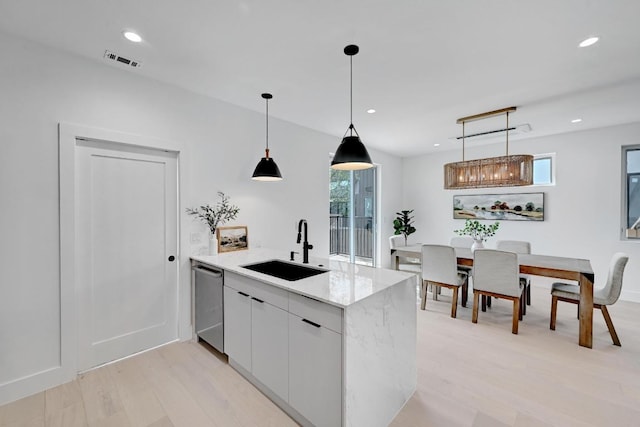 4703 Mount Vernon Dr Unit 1, Austin, TX 78745 - kitchen with dishwasher, light wood-style floors, light stone countertops, pendant lighting, and a peninsula