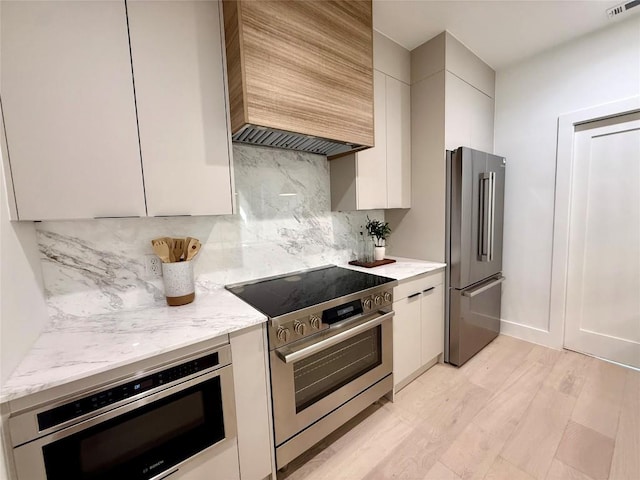 4703 Mount Vernon Dr Unit 1, Austin, TX 78745 - kitchen with stainless steel appliances, modern cabinets, custom range hood, light stone countertops, and backsplash