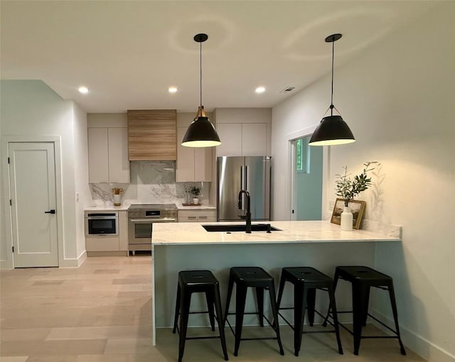 4703 Mount Vernon Dr Unit 1, Austin, TX 78745 - kitchen featuring appliances with stainless steel finishes, custom range hood, a breakfast bar, tasteful backsplash, and a peninsula