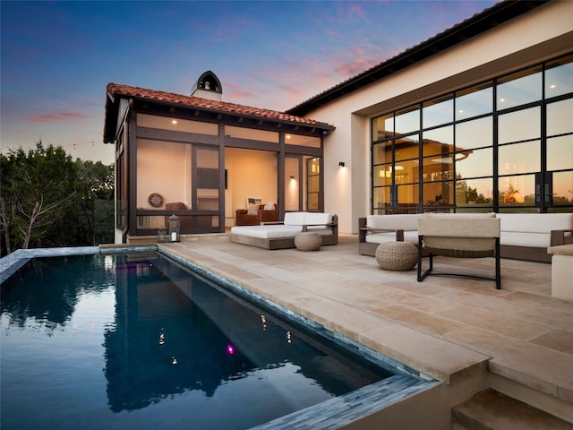 4401 Amarra Dr Unit 14, Austin, TX 78735 - back of property at dusk with a patio area, a tile roof, stucco siding, a chimney, and an outdoor living space