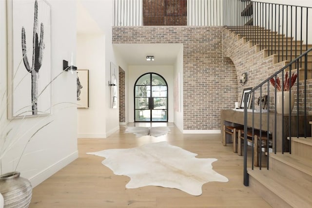 4401 Amarra Dr Unit 14, Austin, TX 78735 - foyer entrance with brick wall, a towering ceiling, wood finished floors, and stairway