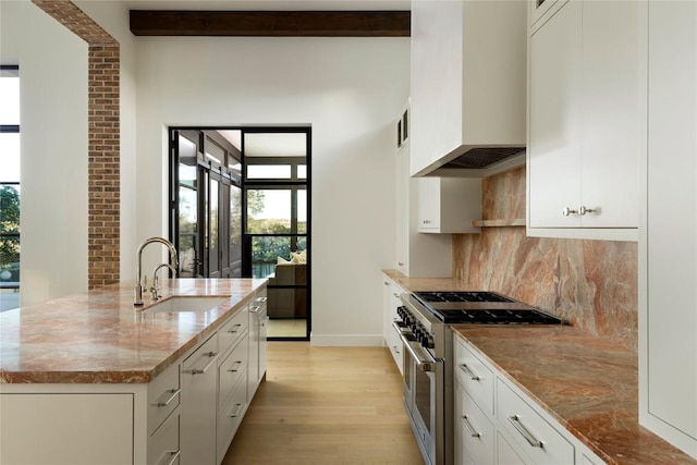 4401 Amarra Dr Unit 14, Austin, TX 78735 - kitchen with range with two ovens, custom exhaust hood, healthy amount of natural light, light wood-style floors, and beamed ceiling