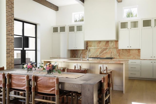 4401 Amarra Dr Unit 14, Austin, TX 78735 - kitchen with tasteful backsplash, beamed ceiling, light wood finished floors, a breakfast bar area, and white cabinets