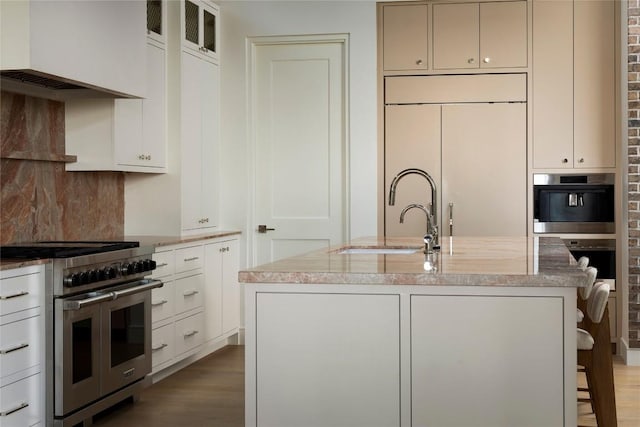 4401 Amarra Dr Unit 14, Austin, TX 78735 - kitchen featuring stainless steel appliances, custom range hood, light stone countertops, wood finished floors, and backsplash
