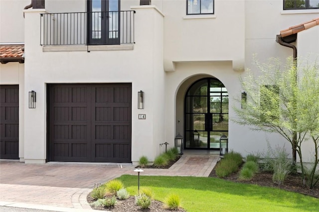 4401 Amarra Dr Unit 14, Austin, TX 78735 - doorway to property with stucco siding, a balcony, an attached garage, and driveway