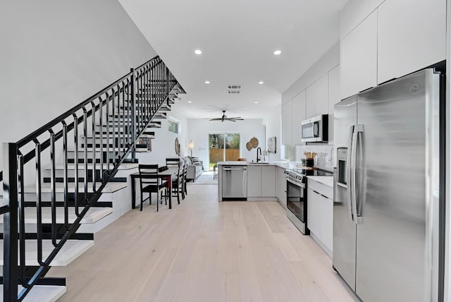 4703 Mount Vernon Dr Unit 2, Austin, TX 78745 - kitchen with stainless steel appliances, a ceiling fan, light wood finished floors, a sink, and modern cabinets