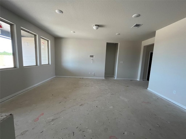 2456 Walking Y Rd, Georgetown, TX 78633 - spare room featuring concrete floors, a textured ceiling, and baseboards