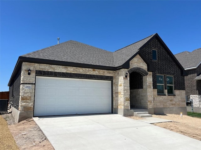 2456 Walking Y Rd, Georgetown, TX 78633 - french country inspired facade featuring stone siding, driveway, a shingled roof, an attached garage, and cooling unit