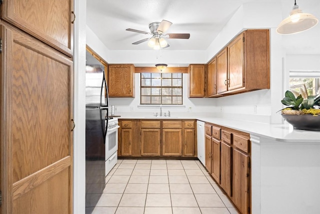 2301 Lawnmont Ave Apt 1, Austin, TX 78756 - kitchen with brown cabinetry, light tile patterned floors, ceiling fan, white appliances, and light countertops