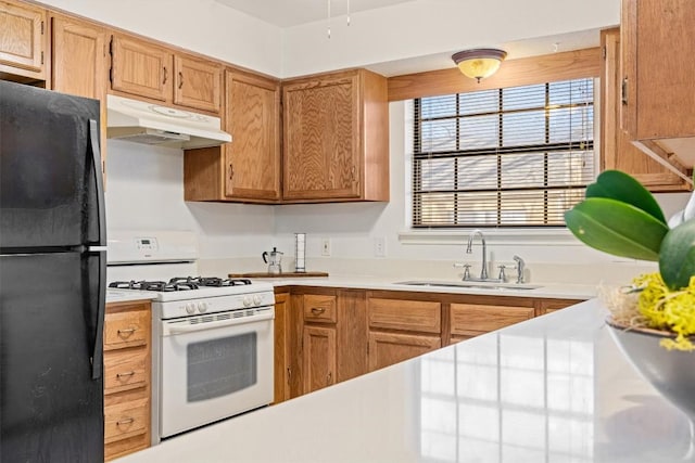 2301 Lawnmont Ave Apt 1, Austin, TX 78756 - kitchen with freestanding refrigerator, gas range gas stove, under cabinet range hood, and light countertops