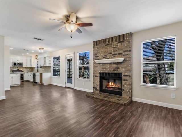 716 Shiny Rock Dr, Austin, TX 78748 - unfurnished living room featuring a ceiling fan, dark wood-type flooring, and a brick fireplace