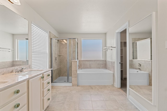 12923 Dwight Eisenhower St, Manor, TX 78653 - full bath featuring a garden tub, vanity, a shower stall, tile patterned floors, and a spacious closet