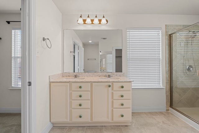 12923 Dwight Eisenhower St, Manor, TX 78653 - bathroom with a shower stall, double vanity, baseboards, and tile patterned floors