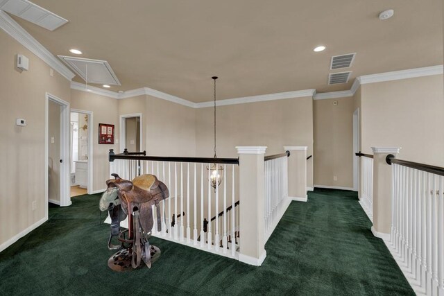 hall with carpet flooring, visible vents, crown molding, and attic access